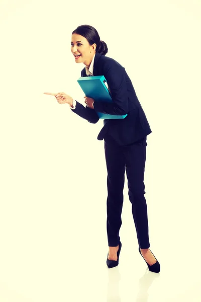 Businesswoman with binder pointing to the left — Stock Photo, Image