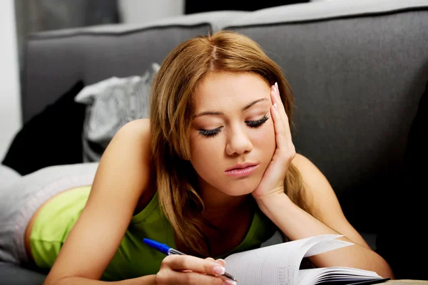 Mladá žena, učení na zkoušku na pohovce. — Stock fotografie