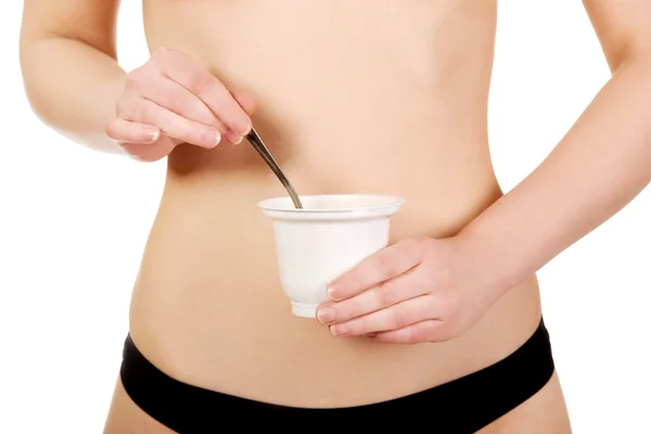 Woman in underwear eating yogurt. — Stock Photo, Image