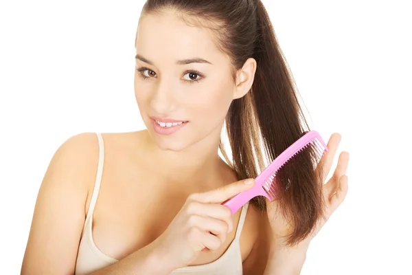 Beautiful woman combs her hair. Stock Picture