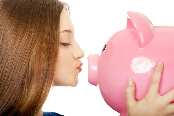 Teenage woman kissing piggybank. — Stock Photo, Image