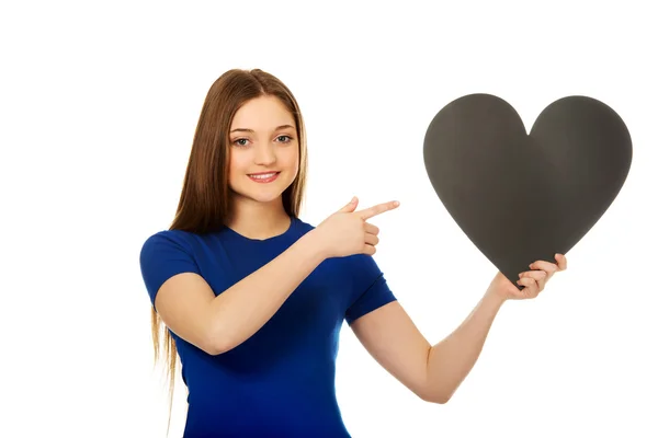 Happy teenager směřující na papírové srdce. — Stock fotografie