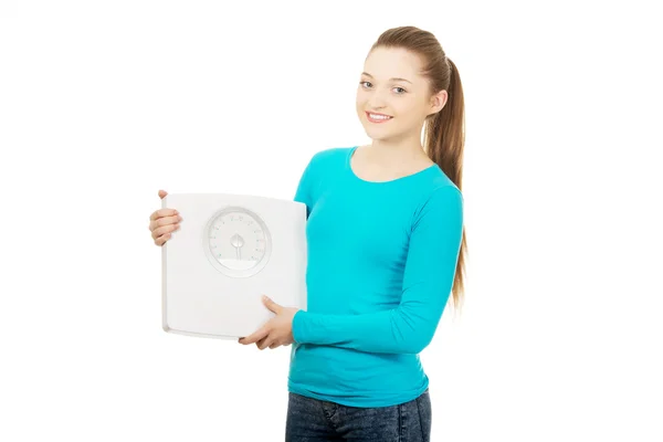 Beautiful teenager holding a scale. — Stock Photo, Image