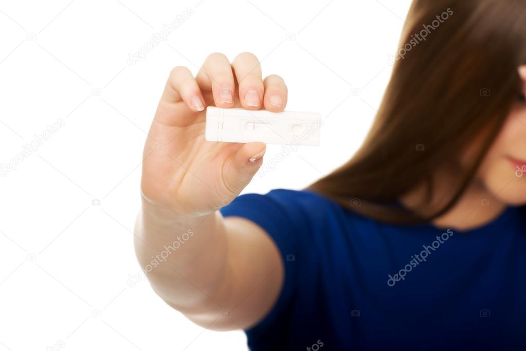 Unhappy woman holding pregnancy test.