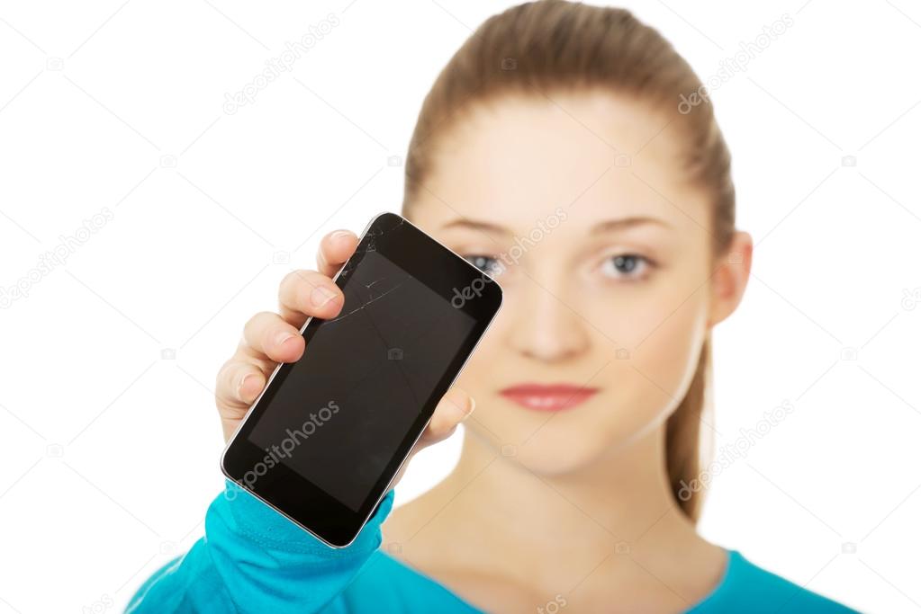 Teen woman with a broken cell phone.