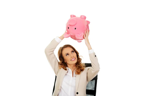 Geschäftsfrau schüttelt Sparschwein. — Stockfoto