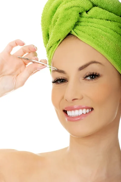 Beautiful woman plucking her eyebrow. — Stock Photo, Image