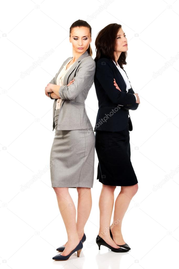 Two businesswoman leaning on each other.