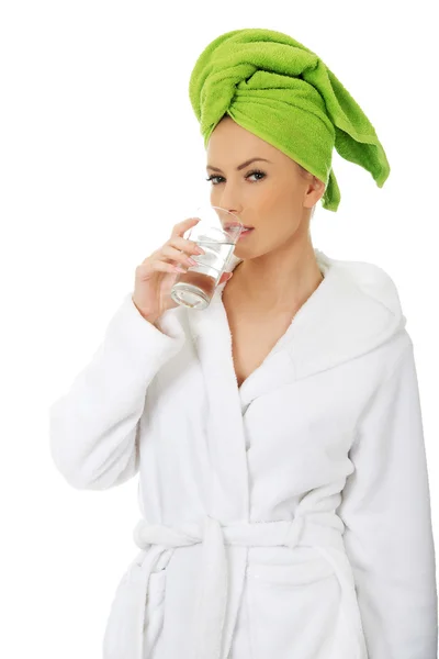 Woman in bathrobe drinks water. — Stock Photo, Image