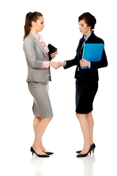Two women with notebooks giving handshake. — Stock Photo, Image