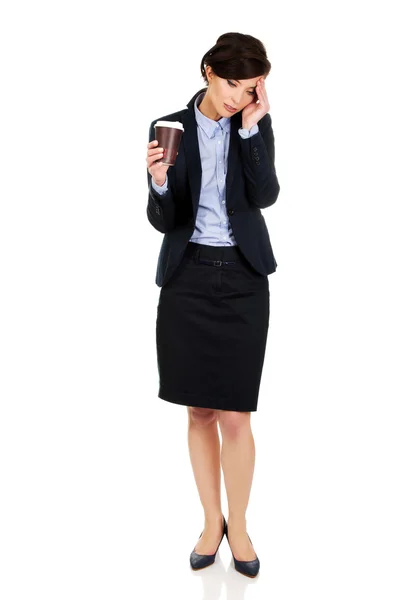 Tired businesswoman holding a cup of coffee. — Stock Photo, Image