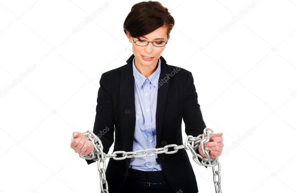 Businesswoman wrapped with metal chain.