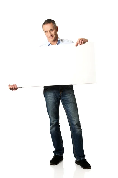 Handsome man holding an empty banner — Stock Photo, Image