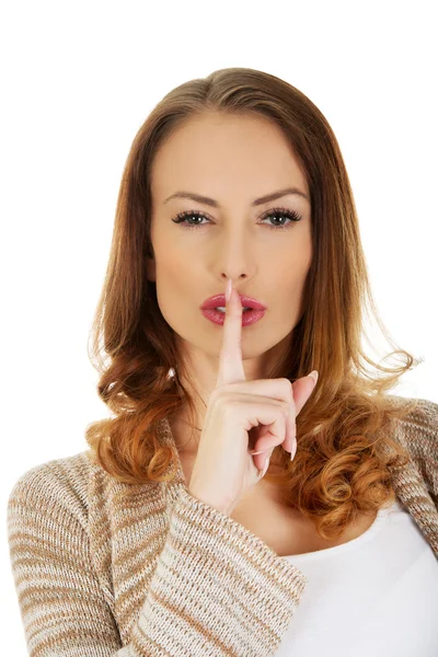 Woman placing finger on lips. — Stock Photo, Image