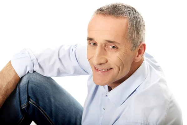 Mature man sitting on the floor — Stock Photo, Image