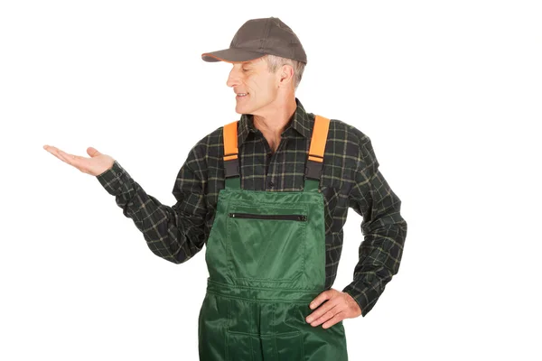 Jardinero en uniforme mostrando espacio a la izquierda — Foto de Stock