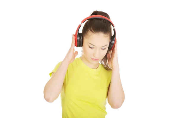 Молода жінка з навушниками слухає музику . — стокове фото