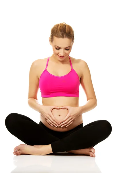 Pregnant woman sitting cross legged — Stock Photo, Image