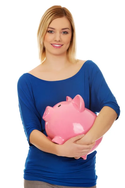 Glückliche Frau hält Sparschwein. — Stockfoto