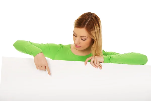 Mujer feliz señalando en tablero en blanco . —  Fotos de Stock