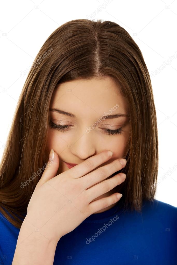 Disgusted teen covering her mouth.