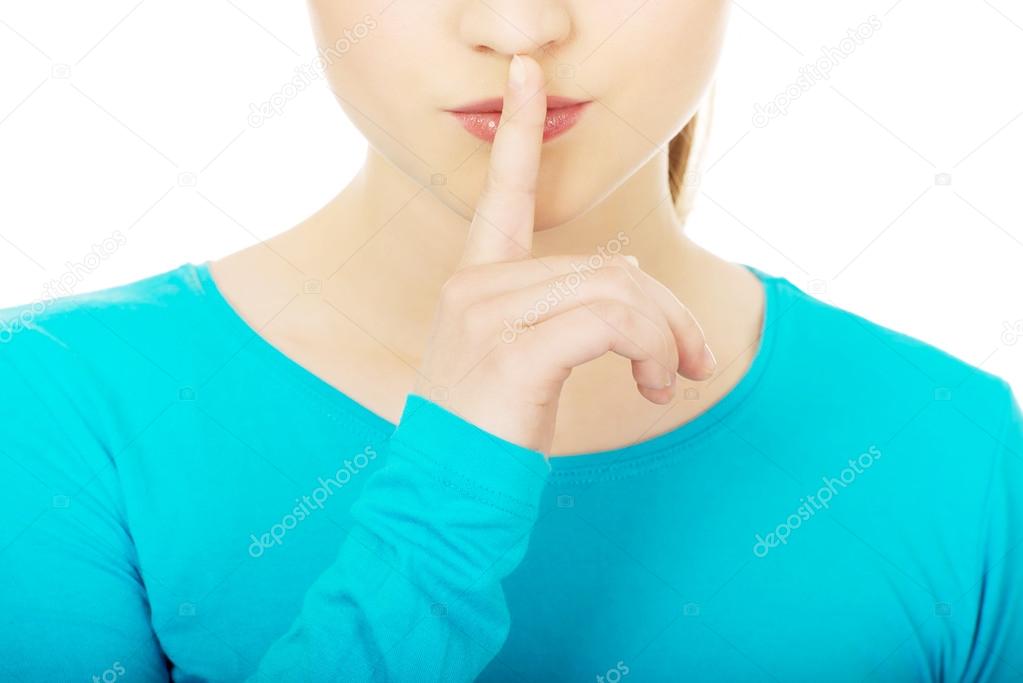 Teen woman with hush gesture.