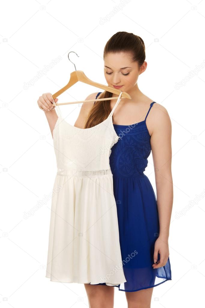 Young woman in dress thinking what to wear.