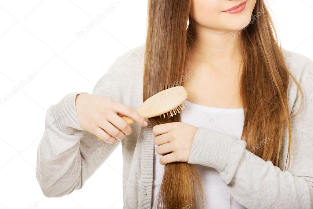 Teen woman brushing her hair.