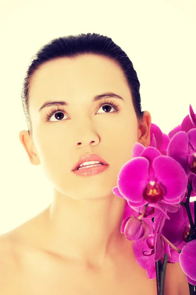 Mulher nua com galho de orquídea roxa — Fotografia de Stock