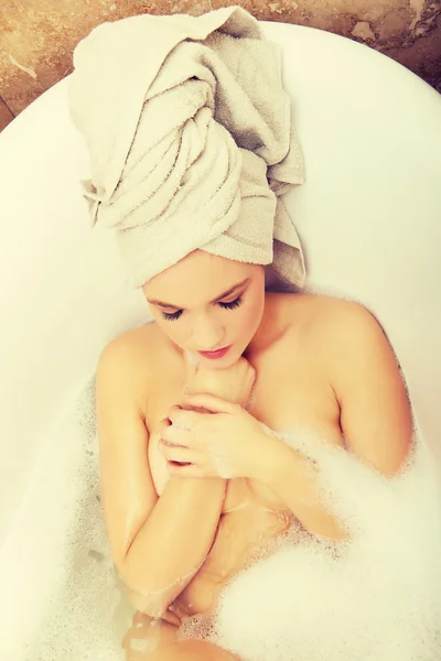 Женщина расслабляется в ванной с закрытыми глазами. — стоковое фото