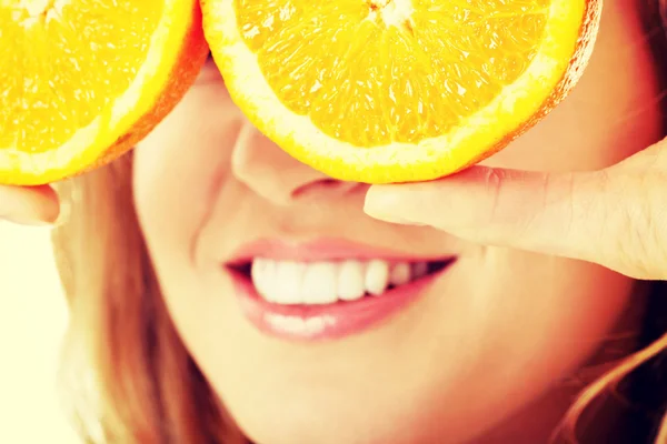 Close up woman holding oranges on eyes — Stock Photo, Image