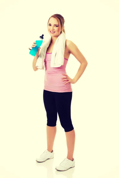 Woman in fitness clothes drinking isotonic drink. — Stock Photo, Image