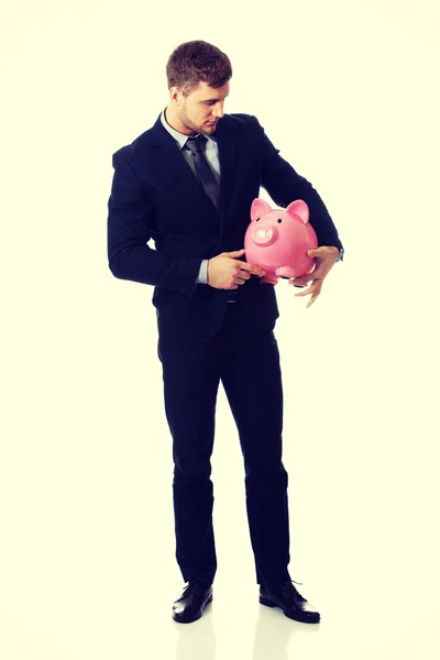 Affärsman som innehar en piggybank. — Stockfoto