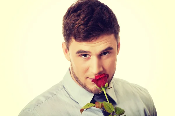 Hombre guapo sosteniendo rosa roja . — Foto de Stock