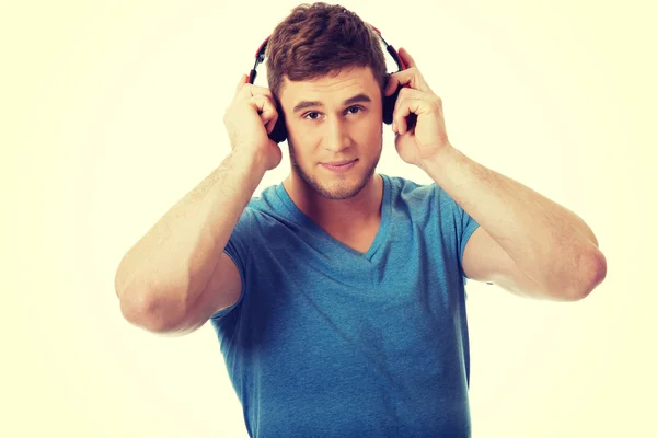 Schöner Mann, der Musik mit Kopfhörern hört. — Stockfoto