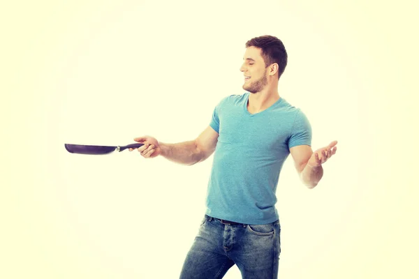 Muscular man holding frying pan. — Stock Photo, Image