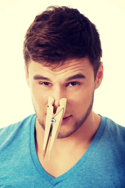 Jeune homme avec une pince à linge sur le nez . — Photo