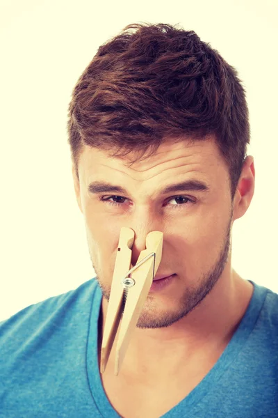 Jeune homme avec une pince à linge sur le nez . — Photo