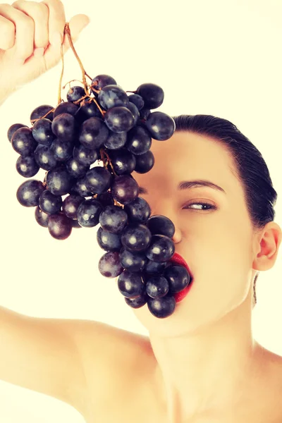 Portrait of nude woman eating grapes — Stock Photo, Image