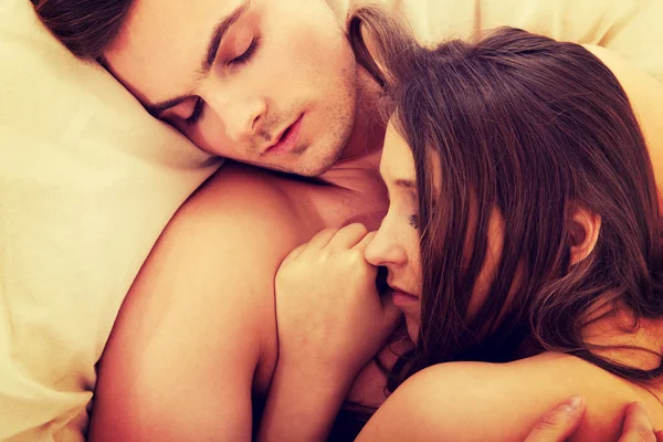 Loving heterosexual couple relaxing in bed. — Stock Photo, Image
