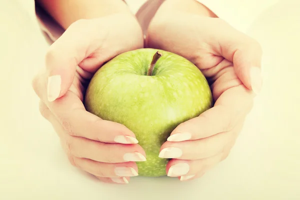 La mela verde grande in belle mani femminili — Foto Stock