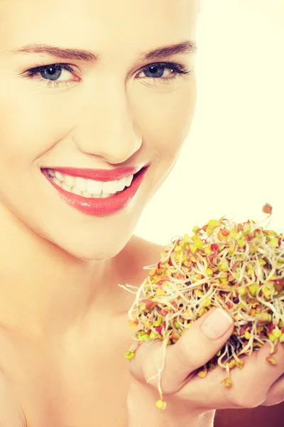 Close up nude woman holding sunflower sprouts — Stock Photo, Image