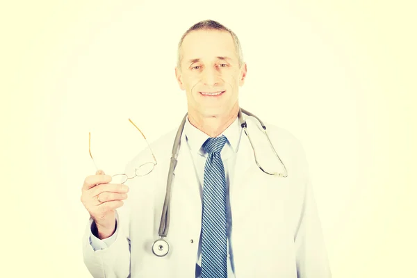 Mature male doctor holding his eyewear — Stock Photo, Image