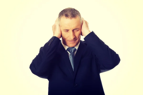 Unavený podnikatel pokrývající uši rukama — Stock fotografie
