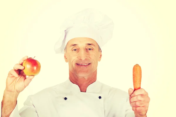 Mužský kuchař s jablky a mrkví — Stock fotografie