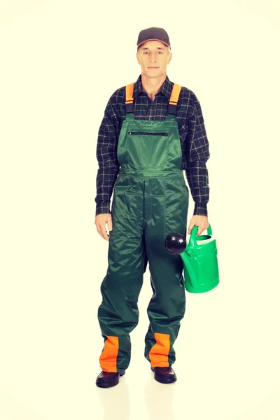 Workman holding green watering can — Stock Photo, Image