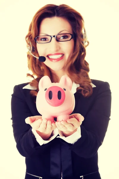 Glückliche Callcenter-Frau mit Sparschwein. — Stockfoto