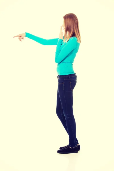 Mujer sorprendida señalando a la izquierda —  Fotos de Stock