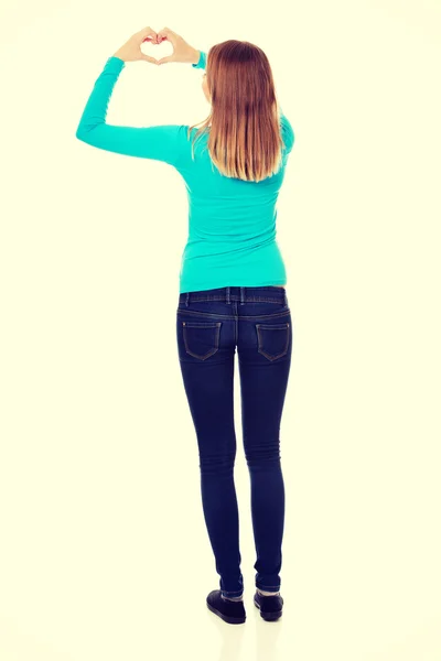 Smiling teenage woman making heart shape — Stock Photo, Image