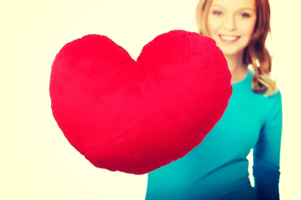 Mujer joven con almohada en forma de corazón — Foto de Stock